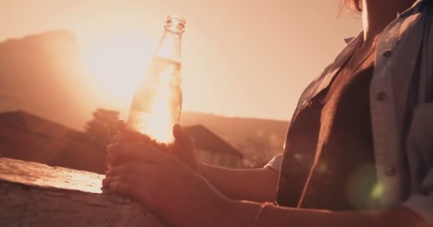 Manos femeninas sosteniendo una cerveza en la azotea al atardecer — Vídeos de Stock