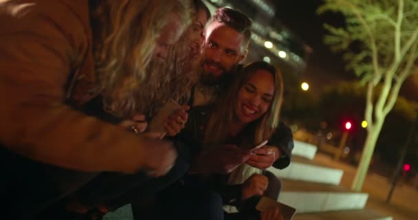 Vrienden zitten buiten op trap met smartphones — Stockvideo