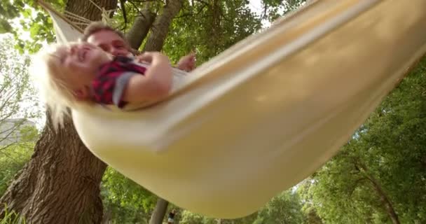 Beau papa étreint son enfant sur un hamac — Video
