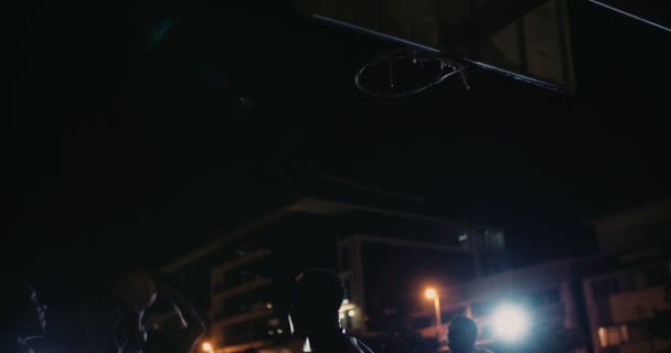 Баскетболист прыгает за кадр в ночи — стоковое видео