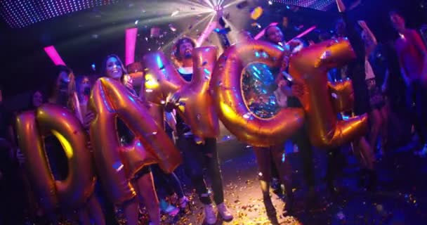 Friends holding dance balloons in night club — Stock Video