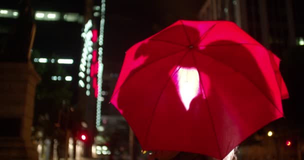 Couple embrassant derrière un parapluie en ville — Video