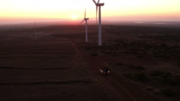 Amigos visitando un parque eólico durante su viaje por carretera — Vídeos de Stock