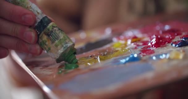 Több színű festékek vegyes késsel a palettán — Stock videók