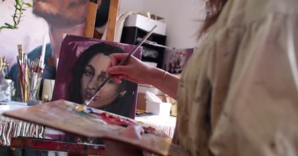 Artist painting self portrait in oil paints on a canvas — Stock Video