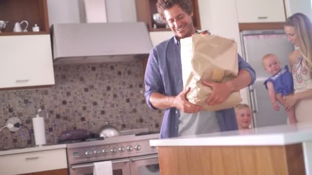 Familie met dochtertje uitpakken van de boodschappen in keuken — Stockvideo