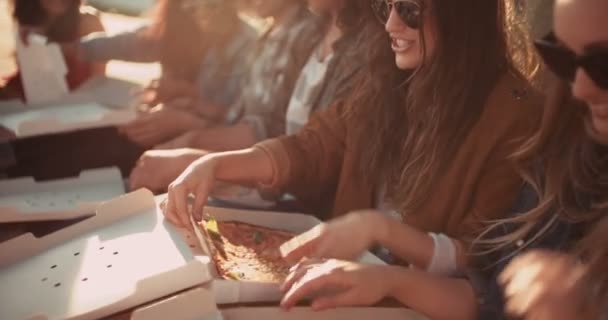 Друзья наслаждаются пиццей на закате во время путешествия — стоковое видео