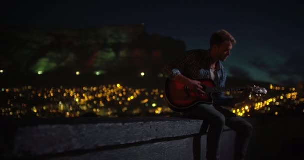 Young man plays guitar for the city — Stock Video