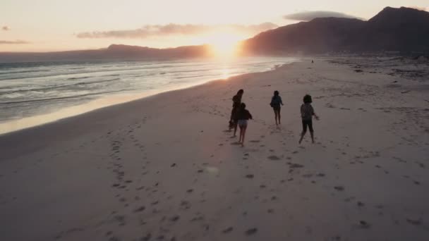 Vänner njuter av en promenad på stranden på sunset — Stockvideo