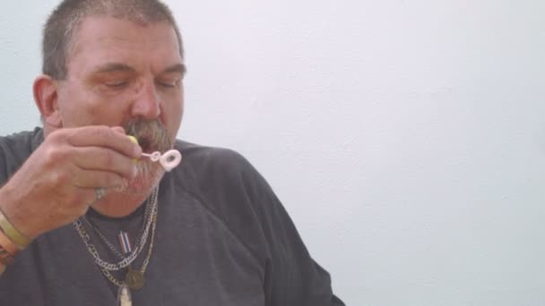 Homem sênior soprando bolhas de sabão — Vídeo de Stock