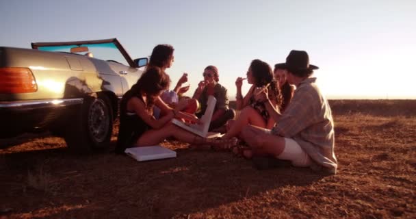 Amigos comiendo pizza al atardecer — Vídeos de Stock