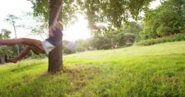 parkta salıncak üzerinde günbatımında oynayan çocuk