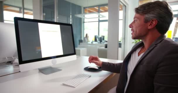 Biznesmen siedząc przed ekranem monitora — Wideo stockowe