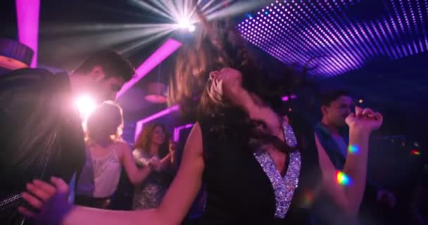 Partij meisje haar haren gooien tijdens het dansen in de nachtclub — Stockvideo