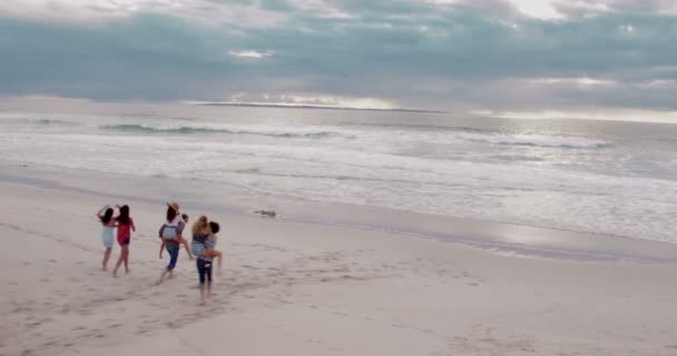 Vrienden hebben grappig meeliften ritten op strand — Stockvideo