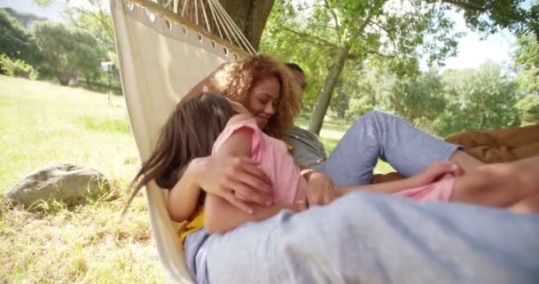 Familia multiétnica relajándose juntos en una hamaca — Vídeo de stock