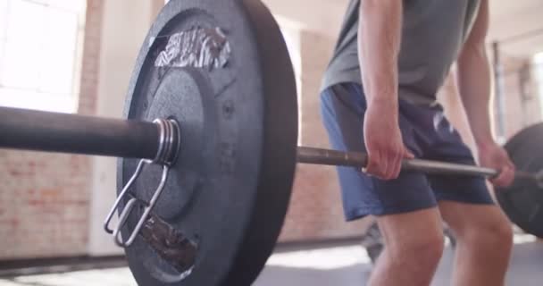 Мужчина делает подъем тяжести во время тренировки по кроссфиту — стоковое видео