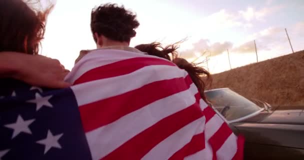 Vrienden lopen op landweg met Amerikaanse vlag — Stockvideo