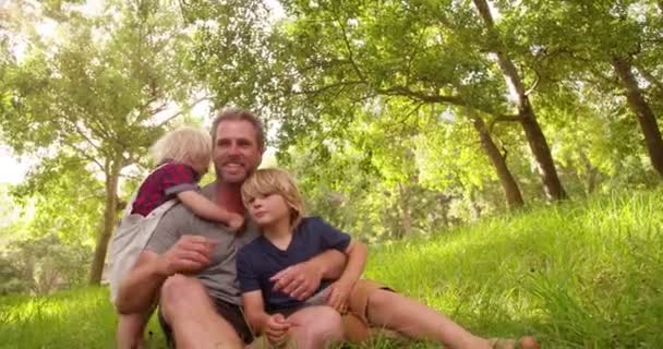 Niño recibe abrazos de su padre en el parque — Vídeo de stock