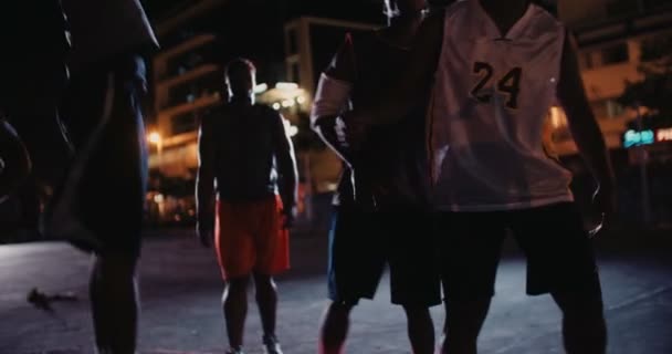Баскетболисты играют на корте в ночное время — стоковое видео
