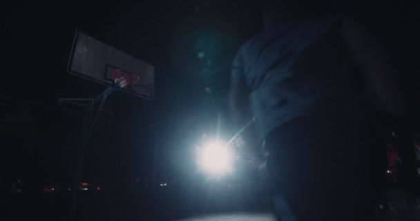 Баскетболисты играют на корте в ночное время — стоковое видео