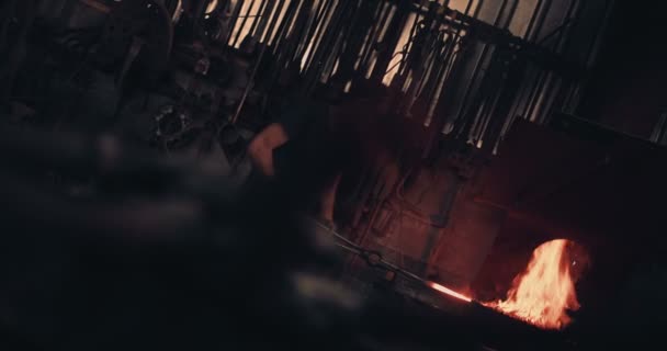 Blacksmith working iron on a forge with fire — Stock Video