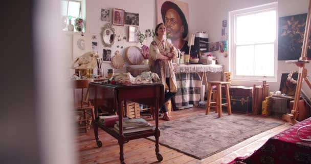 Kunstenaar glimlachend in haar atelier en houdt penselen — Stockvideo