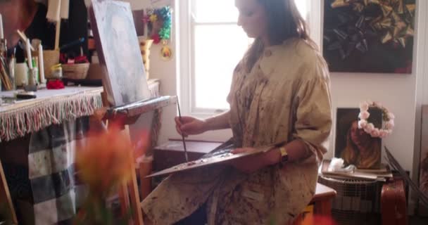 Artist painting a canvas in her studio — Stock Video