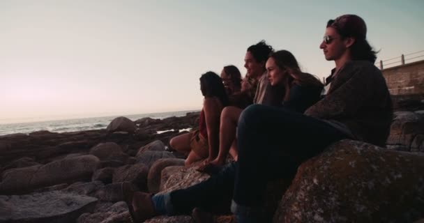 Amici rilassante guardando il tramonto dalle rocce — Video Stock