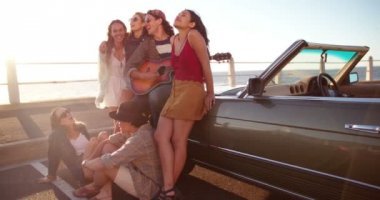 arkadaşlar bir gitar ile bir plaj günbatımı kutluyor