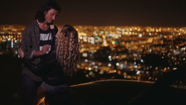 Pareja abrazando y mirando las luces nocturnas de la ciudad — Vídeo de stock