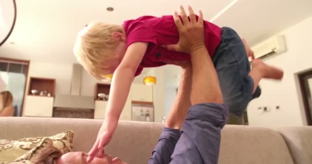 Vader speelt met zoon op de sofa thuis — Stockvideo