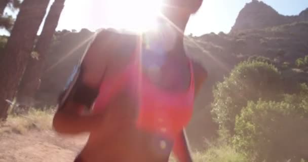 Jogger ascoltare auricolari su un sentiero di montagna — Video Stock