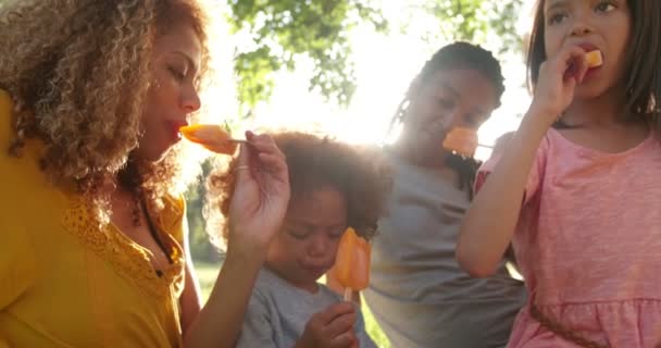 Pareja comiendo helado al sol con niños — Vídeos de Stock