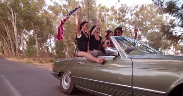 Menina segurando uma bandeira americana em uma viagem de carro — Vídeo de Stock