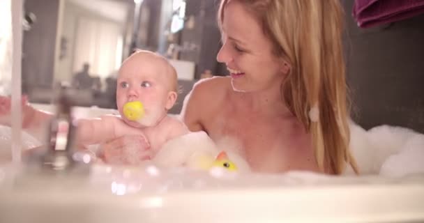 Мама принимает ванну с пузырьком с младенческой дочерью — стоковое видео
