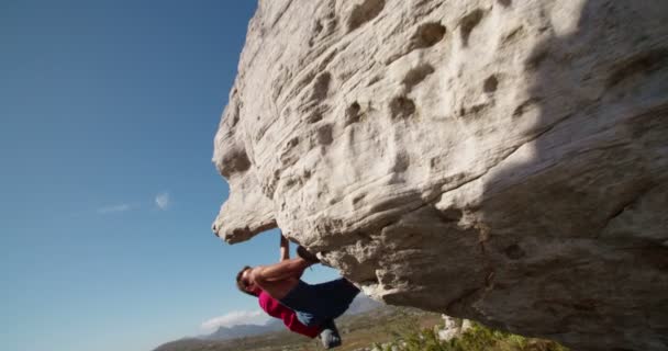 Rock climber holding to boulder and focused on route — Stock Video