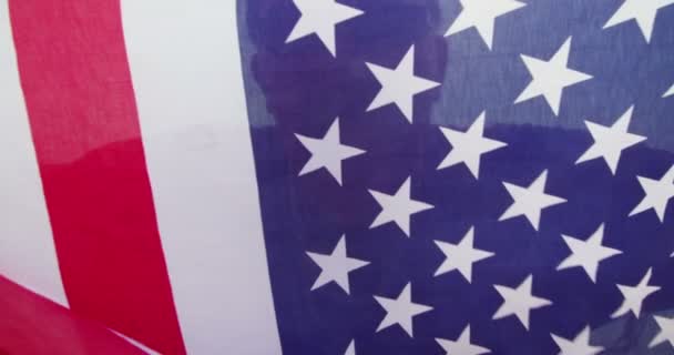 Amerikanischer Patriot posiert und versteckt sich hinter Flagge — Stockvideo