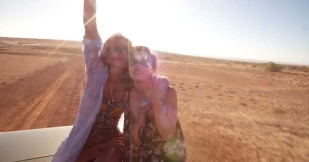 Amigos animando con los brazos levantados en un convertible — Vídeos de Stock