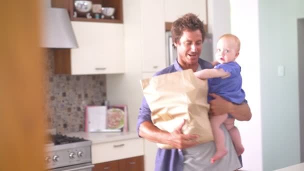 Papa uitpakken boodschappen met baby meisje — Stockvideo