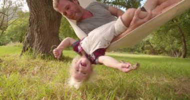 Baba onun çocuğuna bir hamak çalış.