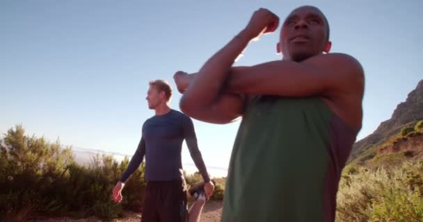 Atletas haciendo ejercicio de estiramiento isquiotibial afuera — Vídeos de Stock