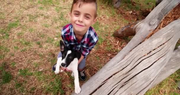 Cachorro y niño mirando a la cámara en la naturaleza — Vídeos de Stock