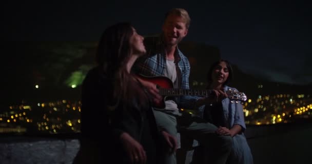 Adam kızlar için gitar çalıyor ve şarkı söylüyor — Stok video