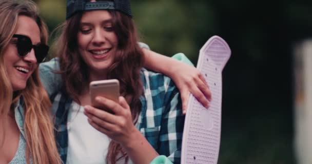 Chicas riendo de algo en el teléfono móvil — Vídeos de Stock