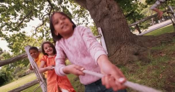 Друзі дитинства грають у парку разом з мотузкою — стокове відео