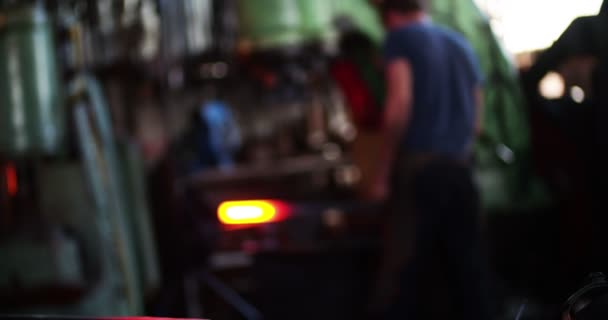 Fer brillant avec forgeron travaillant en arrière-plan 