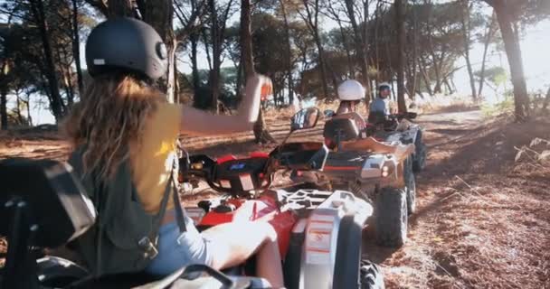 Vänner som sitter på fyrhjulingar i skogen — Stockvideo