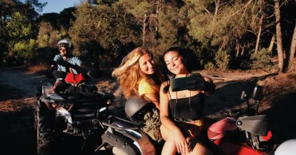 Chicas sonriendo tomando selfie con teléfono inteligente en quad aventura en bicicleta — Vídeos de Stock