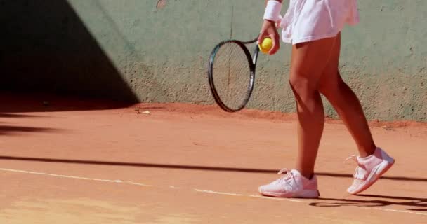 Parte média-baixa da mulher saltando bola no campo de ténis — Vídeo de Stock